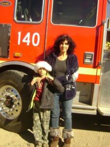 Laurie Millard and Daniel in front of the firetruck.